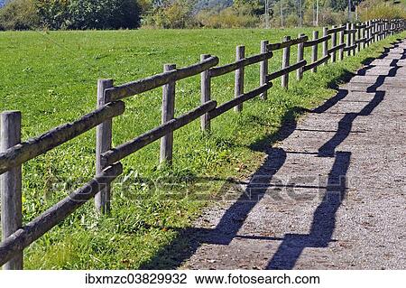 Stock Image - "Fence with a shadow along the promenade path, Buhl am Alpsee, Allgau, Bavaria, Germany, Europe". Fotosearch