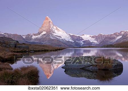 Stock Image - "First morning light on Stellisee Lake overlooking Mt Matterhorn with reflections, Zermatt, Valais, Switzerland, Europe". Fotosearch