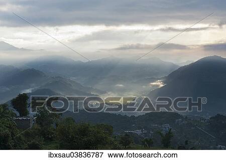 "First sun rays of the morning filtering through the mist, view from above of Pokhara, Sarankot, Himalayas, Nepal, Asia" View Large Photo Image Stock Photo - "First sun rays of the morning filtering through the mist, view from above of Pokhara, Sarankot, Himalayas, Nepal, Asia". Fotosearch