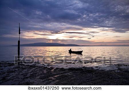 Stock Image - "Fisherman at sunset on Reichenau island, looking towards, Lake Constance, Baden-Wuerttemberg, Germany, Europe". Fotosearch