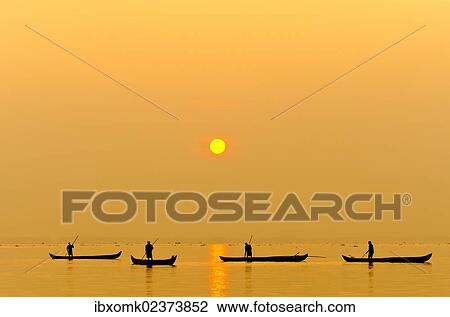 Stock Image - "Fishermen fishing on Lake Vembanad at sunrise, Kerala, southern India, India, Asia". Fotosearch