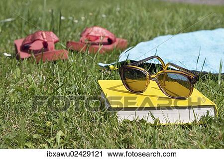 "Flip flops, book and sunglasses on grass" View Large Photo Image Stock Image - "Flip flops, book and sunglasses on grass". Fotosearch