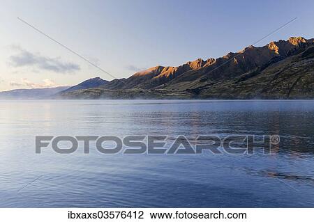 "Fog over Lake Hawea, mountain slopes in the morning light, Hunter Valley, Otago Region, New Zealand, Oceania" View Large Photo Image Stock Image - "Fog over Lake Hawea, mountain slopes in the morning light, Hunter Valley, Otago Region, New Zealand, Oceania". Fotosearch