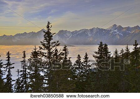 "Fog over the Inn Valley, Karwendel Mountains at the back, at sunset, from Loassattel, Schwaz, Tyrol, Austria, Europe" View Large Photo Image Stock Photo - "Fog over the Inn Valley, Karwendel Mountains at the back, at sunset, from Loassattel, Schwaz, Tyrol, Austria, Europe". Fotosearch