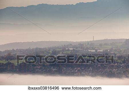 Stock Photograph - "Fog over Uberlingersee lake and Dingelsdorf, Alpstein Massif at the rear, Baden-Wurttemberg, Germany, Europe". Fotosearch