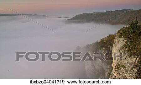 Stock Photo - "Foggy atmosphere in the upper Danube valley view from the Eichfelsen lookout point, Upper Danube Nature Park, Swabian Jura, Baden-Wurttemberg, Germany, Europe". Fotosearch