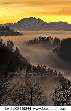 Picture - "Foggy mood in the evening light with view on Mt. Pilatus, Zug, Switzerland, Europe". Fotosearch