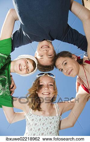 "Four friends standing in a circle embracing each other, looking downward" View Large Photo Image Stock Image - "Four friends standing in a circle embracing each other, looking downward". Fotosearch