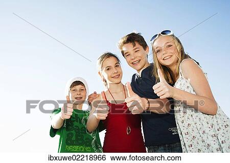 "Four friends standing next to each other, smiling, with their thumbs up" View Large Photo Image Stock Photograph - "Four friends standing next to each other, smiling, with their thumbs up". Fotosearch