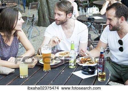 Friends sitting in a beer garden View Large Photo Image Picture - Friends sitting in a beer garden. Fotosearch