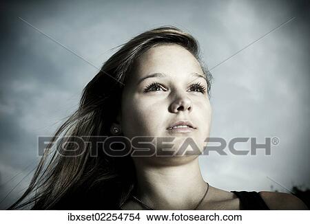 "Girl, 14 years in front of a cloudy sky, portrait" View Large Photo Image Picture - "Girl, 14 years in front of a cloudy sky, portrait". Fotosearch