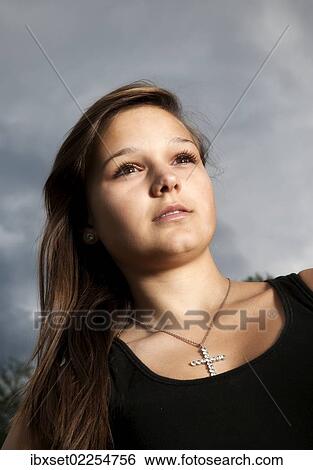 Stock Photograph - "Girl, 14 years, in front of a cloudy sky, portrait". Fotosearch