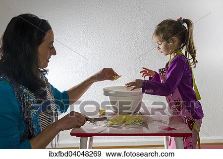 "Girl, 3 years, and her mother, baking, mixing ingredients in a white bowl" View Large Photo Image Stock Photo - "Girl, 3 years, and her mother, baking, mixing ingredients in a white bowl". Fotosearch