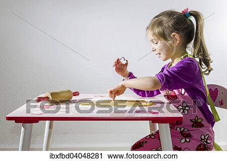 Stock Image - "Girl, 3 years, baking Christmas cookies". Fotosearch