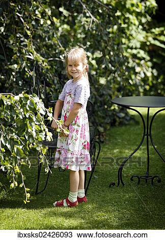 Stock Image - "Girl, 7 years, playing in the garden". Fotosearch