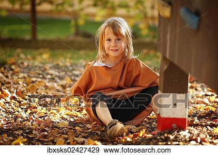 "Girl, 7 years, playing on a playground with autumn foliage" View Large Photo Image Stock Photo - "Girl, 7 years, playing on a playground with autumn foliage". Fotosearch
