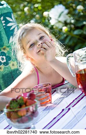 Stock Image - Girl at a garden table. Fotosearch