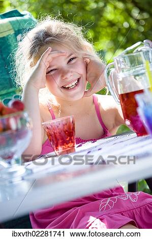 Stock Image - Girl at a garden table. Fotosearch