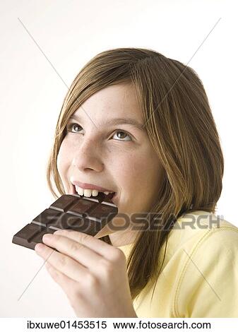 Girl biting into a chocolate bar with pleasure View Large Photo Image Stock Photography - Girl biting into a chocolate bar with pleasure. Fotosearch