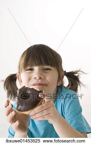 Girl biting into a donut with pleasure View Large Photo Image Stock Photography - Girl biting into a donut with pleasure. Fotosearch