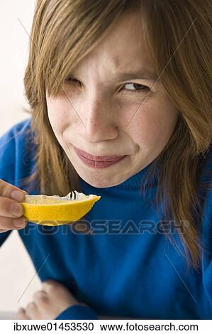 Girl biting into a lemon View Large Photo Image Stock Image - Girl biting into a lemon. Fotosearch