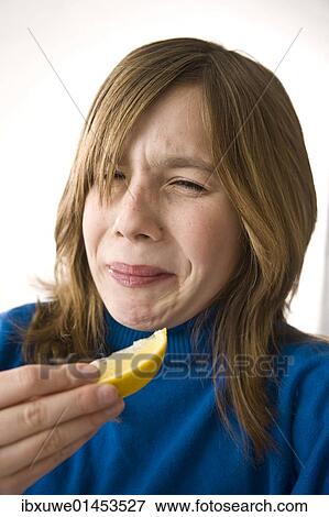 Girl biting into a lemon View Large Photo Image Stock Photo - Girl biting into a lemon. Fotosearch