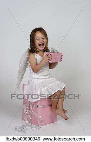 "Girl dressed as angel, with Christmas gifts" View Large Photo Image Stock Photograph - "Girl dressed as angel, with Christmas gifts". Fotosearch