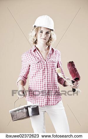 Stock Image - Girl dressed like a painter wearing a hard hat. Fotosearch