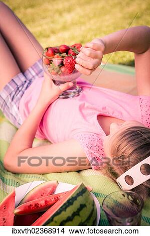 Girl eating strawberries in the garden View Large Photo Image Picture - Girl eating strawberries in the garden. Fotosearch