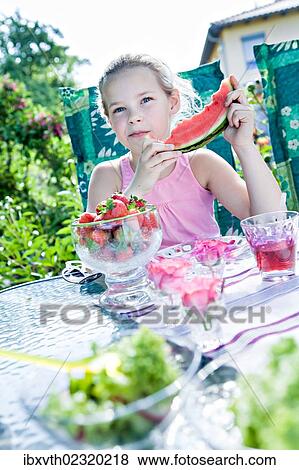 Girl eating watermelon in the garden View Large Photo Image Stock Photo - Girl eating watermelon in the garden. Fotosearch