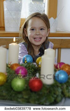 Girl enjoying the first lit candle on the Advent wreath View Large Photo Image Stock Photo - Girl enjoying the first lit candle on the Advent wreath. Fotosearch