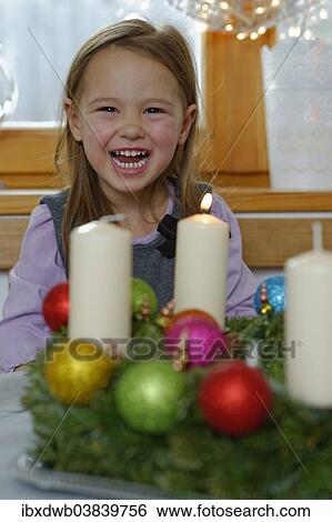 Girl enjoying the first lit candle on the Advent wreath View Large Photo Image Stock Photograph - Girl enjoying the first lit candle on the Advent wreath. Fotosearch