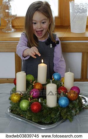 Girl enjoying the first lit candle on the Advent wreath View Large Photo Image Stock Photography - Girl enjoying the first lit candle on the Advent wreath. Fotosearch
