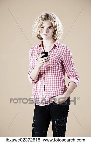 Girl holding a smartphone in her hand View Large Photo Image Stock Photo - Girl holding a smartphone in her hand. Fotosearch