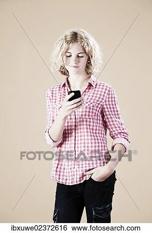 Stock Photograph - Girl holding a smartphone in her hand. Fotosearch