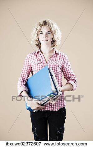 Stock Photo - Girl holding educational material in her arms. Fotosearch