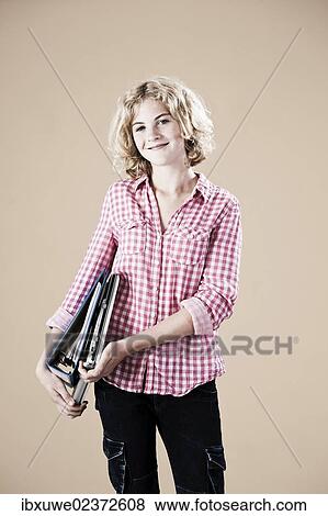 Girl holding educational material in her arms View Large Photo Image Stock Photo - Girl holding educational material in her arms. Fotosearch