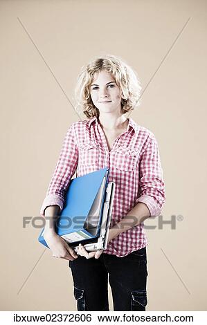 Stock Photograph - Girl holding educational material in her arms. Fotosearch
