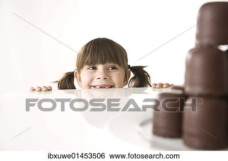 Girl in front of a plate of chocolate marshmallows View Large Photo Image Stock Photograph - Girl in front of a plate of chocolate marshmallows. Fotosearch