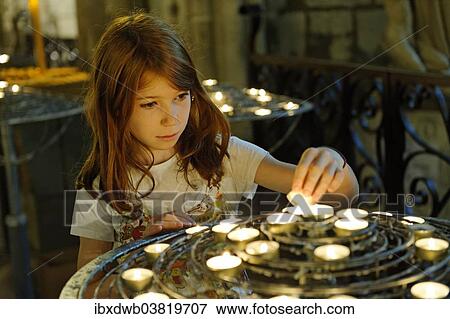 "Girl lighting a devotional candle at Notre-Dame de Paris or Notre-Dame Cathedral, Ile de la Cite, 4th Arrondissement, Paris, France, Europe" View Large Photo Image Stock Photo - "Girl lighting a devotional candle at Notre-Dame de Paris or Notre-Dame Cathedral, Ile de la Cite, 4th Arrondissement, Paris, France, Europe". Fotosearch