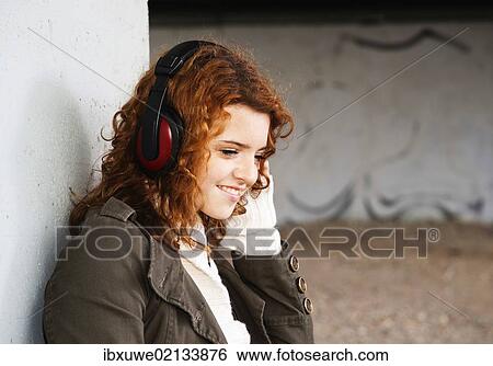 Stock Photograph - Girl listening to music with headphones. Fotosearch
