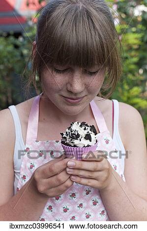 Girl looking at a homemade Oreo brownie cupcake View Large Photo Image Stock Image - Girl looking at a homemade Oreo brownie cupcake. Fotosearch