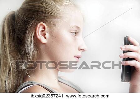 Girl looking at a smartphone View Large Photo Image Stock Image - Girl looking at a smartphone. Fotosearch