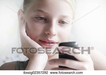 Girl looking at a smartphone View Large Photo Image Stock Image - Girl looking at a smartphone. Fotosearch