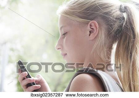 Stock Photo - Girl looking at a smartphone. Fotosearch
