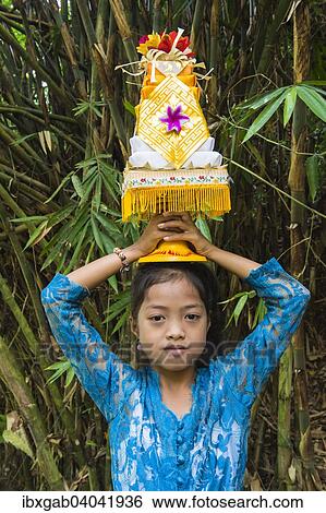 "Girl on the way to the temple, carrying offerings for a ceremony on her head, Bali, Indonesia, Asia" View Large Photo Image Stock Photograph - "Girl on the way to the temple, carrying offerings for a ceremony on her head, Bali, Indonesia, Asia". Fotosearch