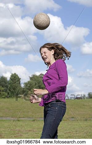 Picture - "Girl playing football, heading ball". Fotosearch