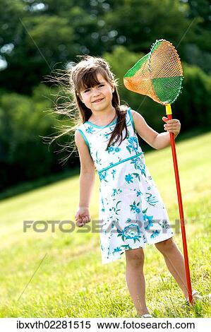 Stock Photography - Girl playing with butterfly net in the garden. Fotosearch