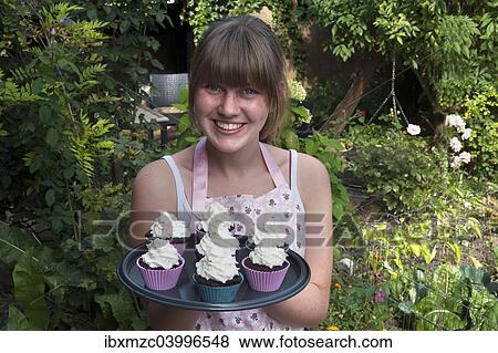 Stock Photo - Girl presenting her homemade Oreo brownie cupcakes. Fotosearch