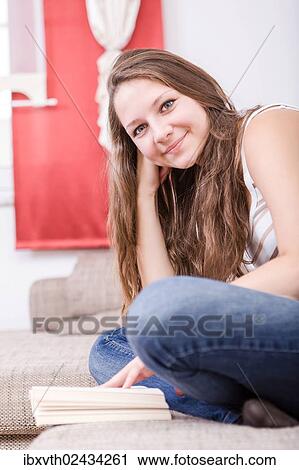 Stock Image - Girl reading a book at home. Fotosearch